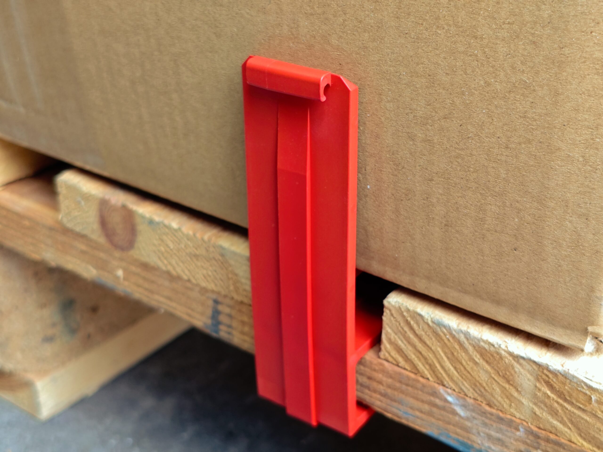 Warensicherung Paletten-HaSi in rot sichert einen Karton auf einer Palette